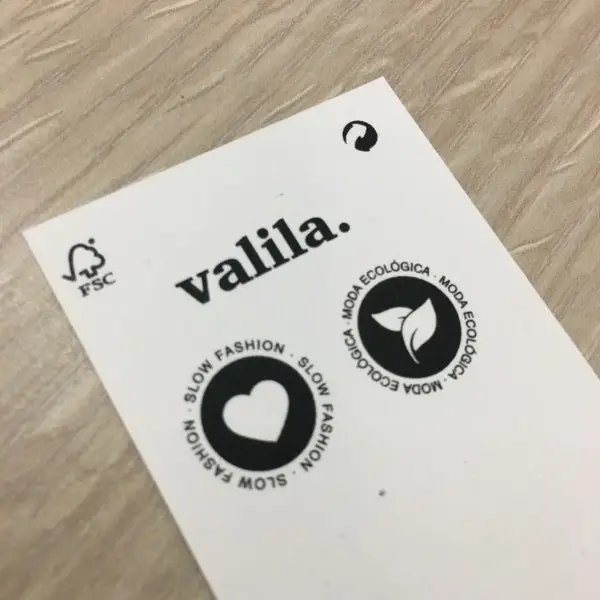 Reverso de Etiqueta blanca con letras negras y logos.